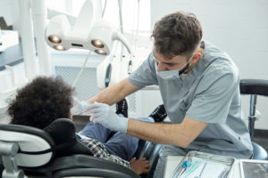 dentist bending over little boy while drilling his 2022 01 20 15 49 24 utc