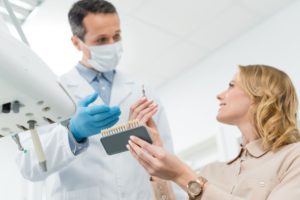 doctor showing tooth implants to female patient in 2022 12 16 17 54 11 utc