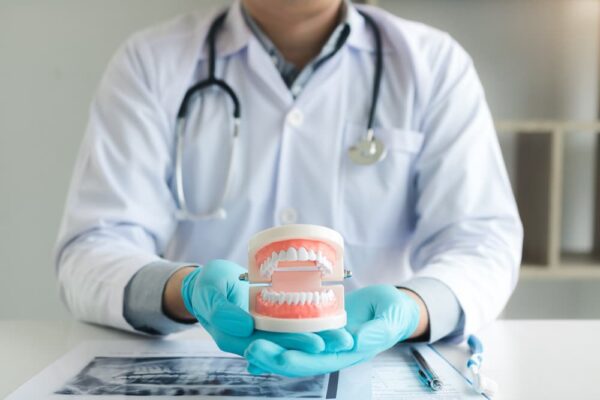 dentist-holding-dentures-in-office-room-TM38LES (1)